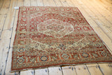 High-angle view of a vintage Tabriz rug with its serrated medallions and terracotta field.
