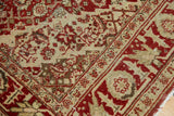 Serrated border detail in terra cotta rust and sand on a low-pile vintage rug.