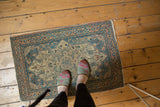 Patinaed side and corner of a traditional Haji Jalili Tabriz rug, featuring dusty teal, rose, and ivory.
