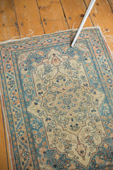 Patinaed intricate book cover medallion and dusty teal floral patterns of the antique Tabriz rug.