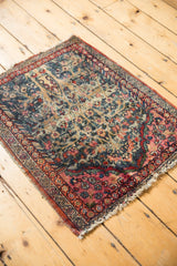 Vintage Kerman rug corner detail with abrash, floral motifs, and tattered raspberry red borders.