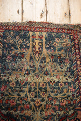 Vintage Kerman rug detail: tree of life, abrash in slate blue, and tattered edge.