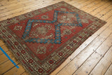 Antique Caucasian rug, brick red and aqua geometric patterns, with visible even pile wear.