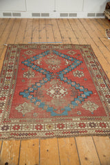 Antique Caucasian rug: geometric brick red border, aqua blue pattern, and overcast end.