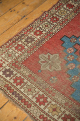 Antique Caucasian rug corner: geometric border, brick red field, aqua blue motif, and mostly even wear.