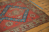 Antique Caucasian rug corner detail, featuring geometric borders in brick red and aqua, with mostly even wear.