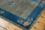 Cobalt blue border and muted floral motifs on a worn slate blue gray antique Peking rug.