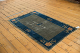 Antique Chinese Peking rug lower corner, cobalt blue border, peach floral designs, worn gray-green pile.