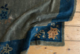 Antique Peking rug's folded corner, blue border, and muted green field with foundation wear.