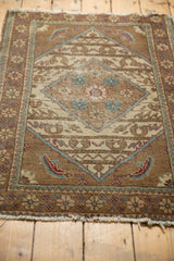 Vintage Sparta rug corner, revealing a floral border with soft blue and blush, and frayed fringe.