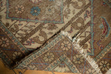 Vintage Sparta rug corner with faded floral motifs, tattered fringe, and visible foundation wear.