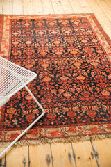 Vintage Malayer rug corner with light tattered fringe, detailed floral pattern, and even pile wear.