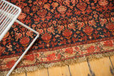 Lightly tattered fringe with a floral border in ivory, red, and dark charcoal.