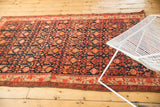 Vintage Malayer rug end with light tatter, red floral border, and dark field.