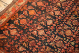 Close-up of vintage Malayer rug's allover floral pattern, navy ground, tangerine, and light tatter.