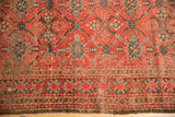 Tattered antique Beshir carpet detail, showing madder red geometric pattern and exposed foundation.