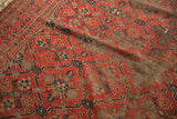 Antique Beshir carpet's madder red lattice design with significant pile wear and visible foundation.