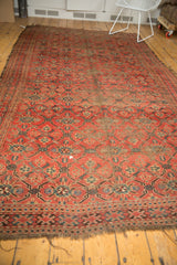 Antique Beshir carpet's lower border, tattered end, madder red lattice, and visible foundation.