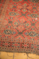 Antique Beshir carpet edge, revealing tattered madder red pile and lattice geometric motifs.