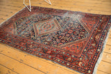 Hand-knotted vintage Mahal rug with rich colors and visible tattering along its borders.
