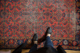 Close view of vintage Lilihan rug with cherry red field, floating Herati motif, and patina.