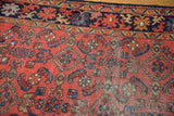 Detail of vintage Lilihan rug's madder red field with floating Herati motifs and visible knot heads.