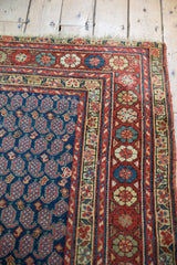 Vintage Northwest Persian rug: navy boteh field and vibrant floral border at corner.