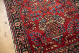 Raspberry red vintage Lilihan rug with intricate floral motifs and scattered white knots.