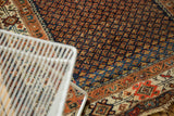 Vintage Hamadan rug, worn navy and burnt orange boteh field, ivory border, tattered edge.