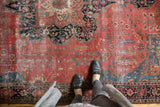 Antique Farahan Sarouk carpet: raspberry field, blue tendrils, classic border, and textural wear.