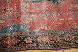 Antique Farahan Sarouk detail: raspberry field tendrils, classic navy border, visible wear.