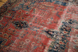 Antique Farahan Sarouk detail: raspberry red field, navy floral motifs, and aged soft pile.