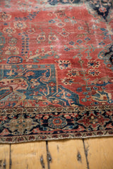 Delicate tendrils on raspberry field and classic navy floral border of Farahan Sarouk.