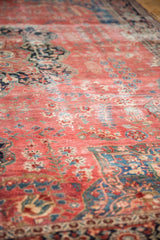 Antique Farahan Sarouk carpet with raspberry red field, delicate floral motifs, soft pile, and visible foundation.