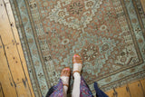 Decorative field of distressed geometric-floral patterns in soft copper, sea foam, and ivory tones.
