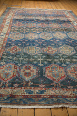 Frayed fringe and worn geometric border of the Baktiari rug.