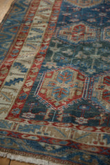 Distressed Baktiari carpet with muted sky blue, cherry red, and sand panel motifs.