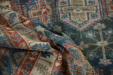 Distressed Baktiari carpet's allover panel design with muted blues, cherry red, and sand tones.