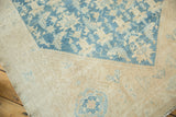 Distressed Malayer rug corner with stylized blue Herati pattern and soft beige border.