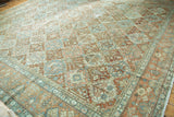 Distressed Persian Baktiari rug corner with terracotta, teal, and blush Gardens of Paradise design.