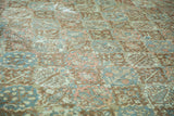 Distressed Baktiari carpet with faded terracotta, slate blue, ivory garden motifs.
