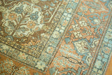 Textured pile of a distressed Baktiari carpet, showing faded terracotta and teal floral motifs.