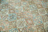 Distressed vintage Baktiari rug pile, with terracotta, blue, blush garden motifs.