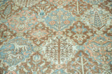 Distressed Baktiari rug close-up, copper terracotta, blush, blue Gardens of Paradise motifs.