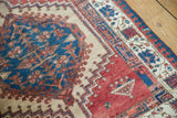 Saturated blue medallion with blush patterns, camel field, and geometric cherry red Serab border.