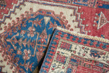 Hand knotted Serab runner showing geometric cherry red and sky blue pile with reverse weave and fringe.