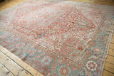 Distressed vintage Heriz carpet displaying rectilinear vinery, palmettes, cherry red, sea foam green.
