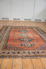 Vintage Malayer rug's abrashed dusty rust blush field with navy geometric border details.