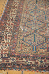 Distressed paneled lattice field and intricate Mir Serbend border of the vintage Malayer rug.