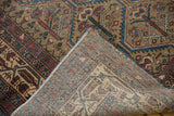 Distressed Malayer rug corner, showing worn pile, tight weave foundation, and older machine binding.